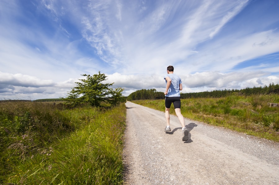 A runner heading down a long gravel road under an open sky